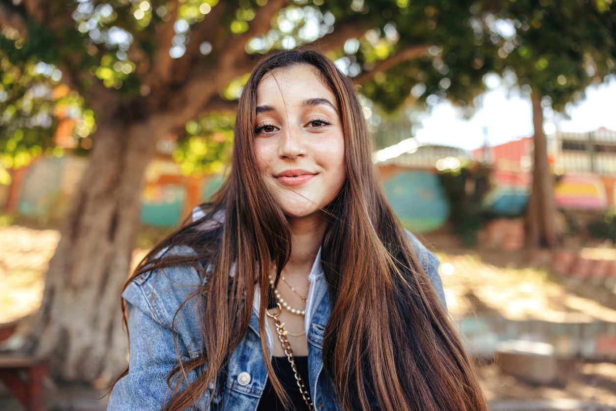 Adorable teenage girl looking at the camera outdoors
