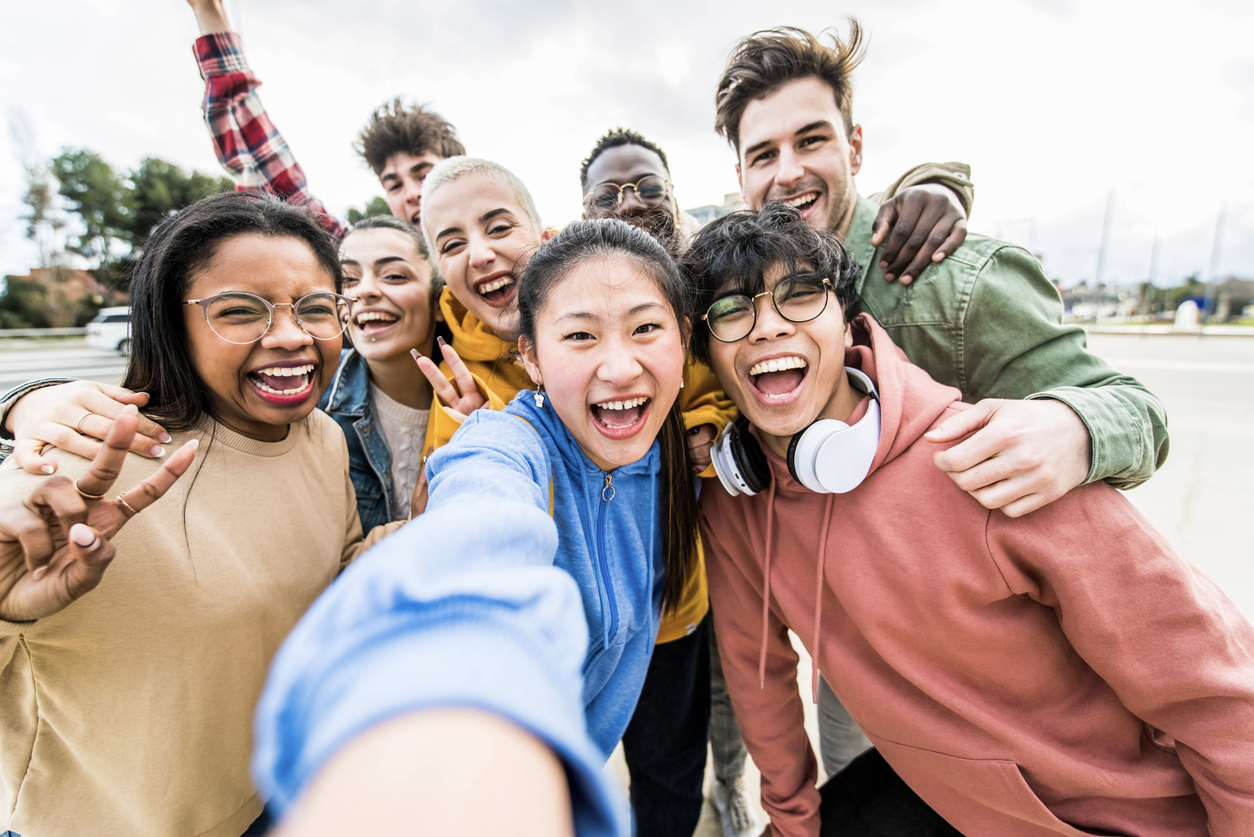 Multiracial friends taking big group selfie shot smiling at camera -Laughing young people standing outdoor and having fun - Cheerful students portrait outside school - Human resources concept